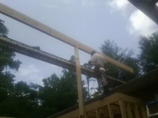 Carpenter setting a ridge beam over a new addition frame — Ice Dam Removal by Roofing Brothers in Ringtown