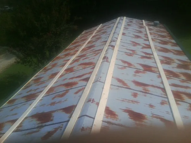Rusted metal roof panels with new wood purlins before replacement — Storm Damage Roof Repair in Ringtown by Roofing Brothers