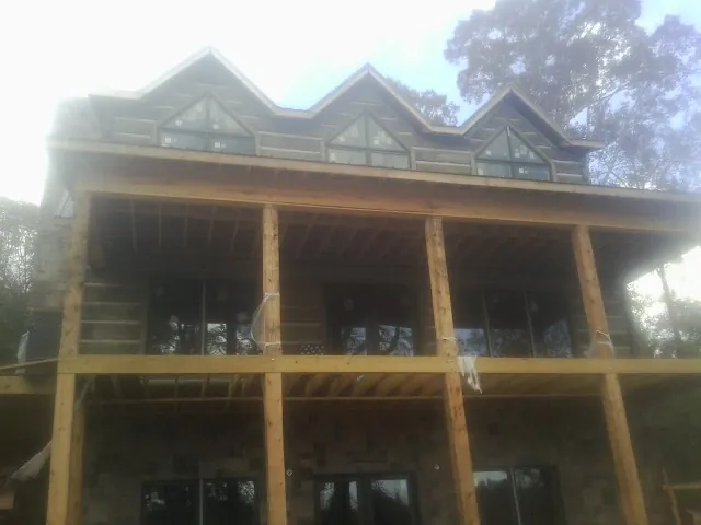Dormers and porch framing on a large log home under construction — Roof Coating work by our crew in Ringtown